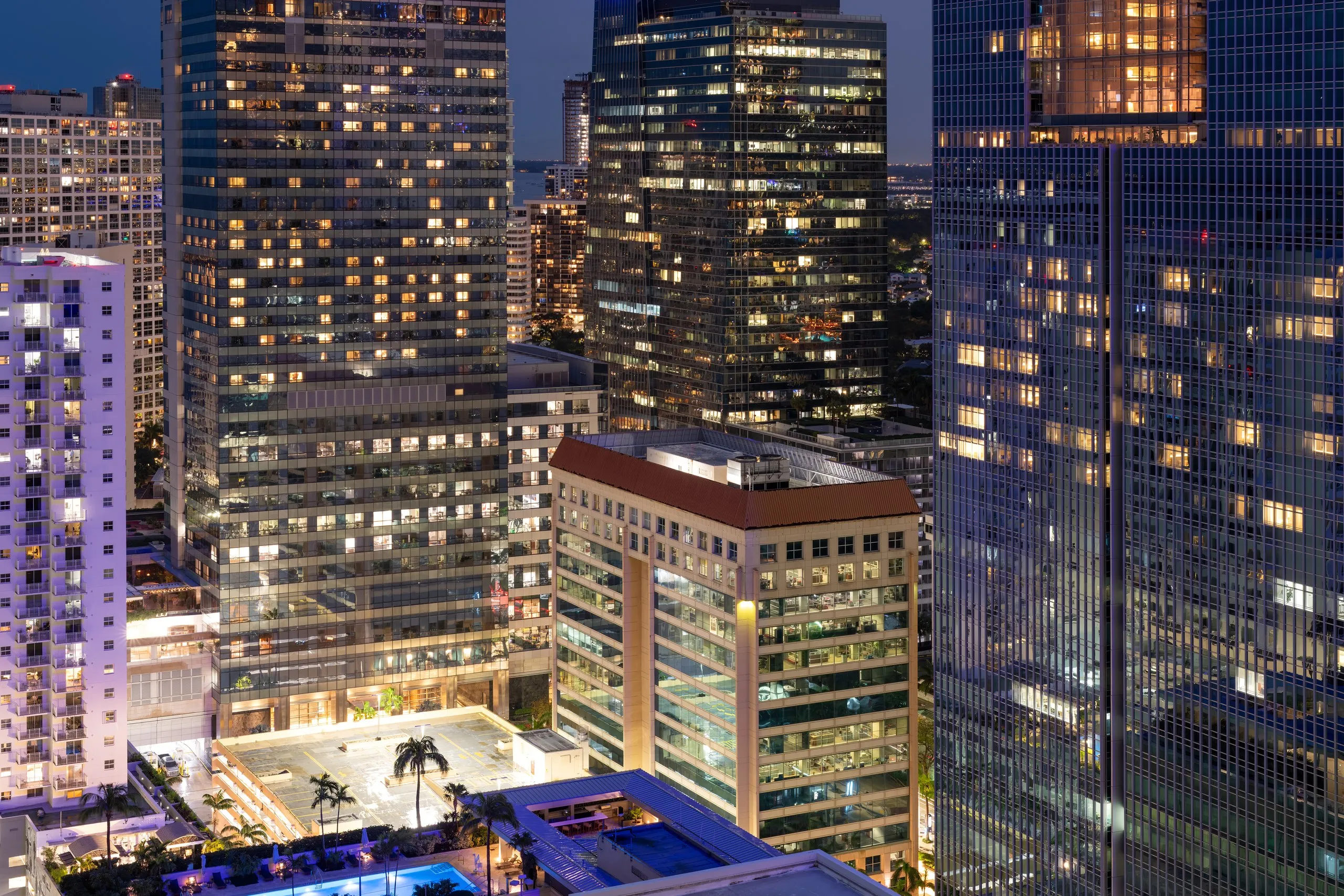 Brickell towers at night, windows lit across the dense cluster of residential and office buildings